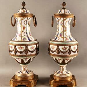 Paire de vases couverts sur piédouche en porcelaine polychrome