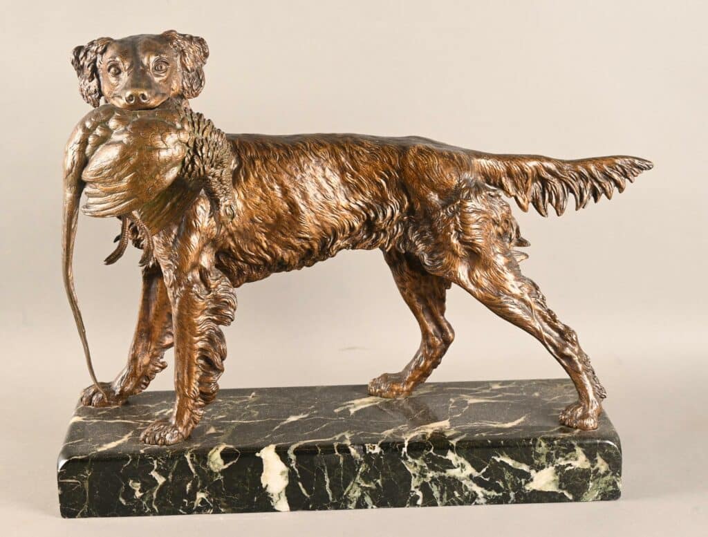 Sculpture en bronze patiné d'un chien avec un faisant dans la gueule.
