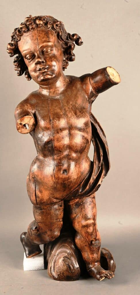 Putti sculpté en bois teinté.