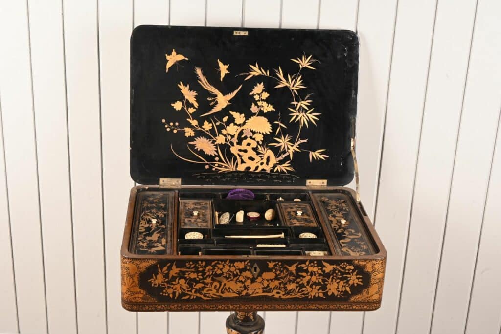 Travailleuse en bois laqué et doré à décor de scènes pittoresques chinoises.