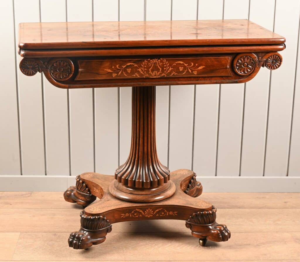 Table à jeux Charles X en palissandre et marqueterie de bois clair.