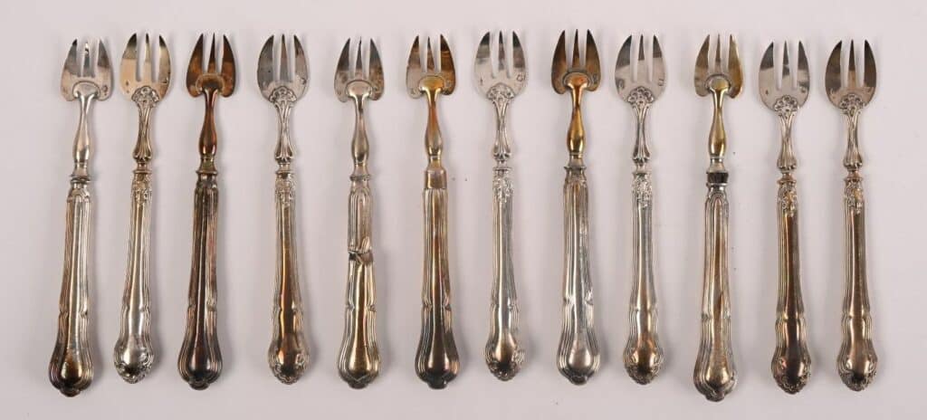 Belle suite de 12 fourchettes à huître en argent 800.